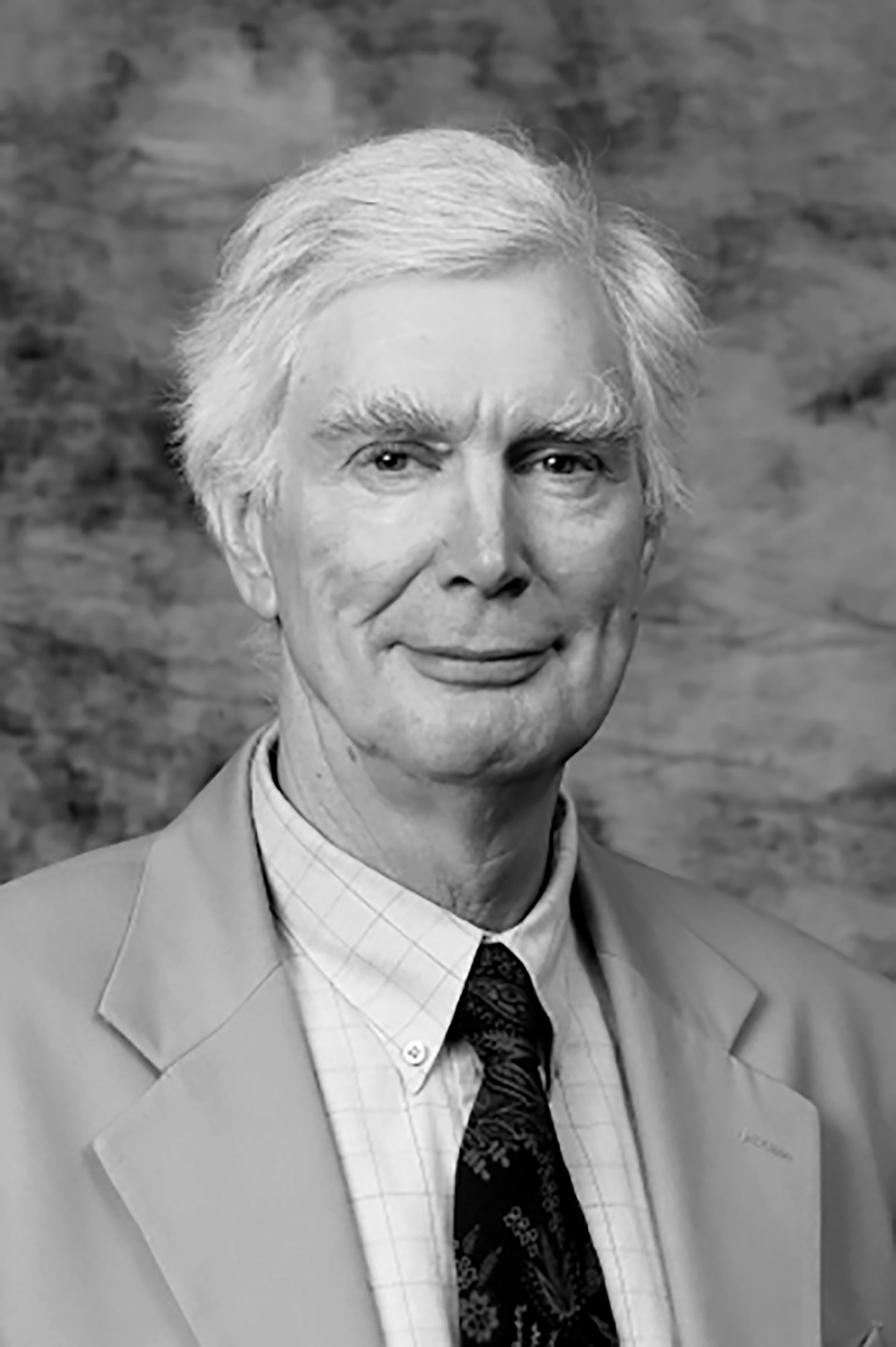 Photo: A black and white photo of David Anable, a white man with white hair wearing a suit.