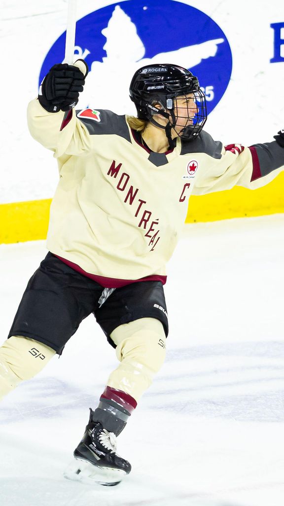 Photo: A Professional Women's hockey goalie wearing a Montréal jersey that is cream-colored with red and black trim, skating on the ice with her hands raised