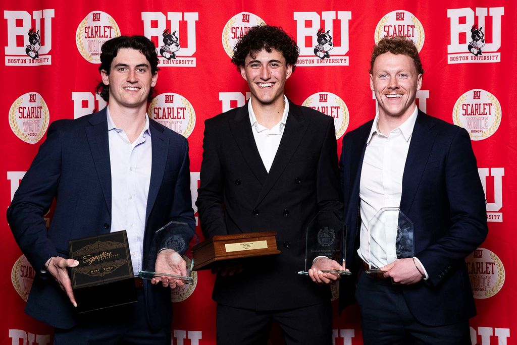 Photo: A picture of three men posing with awards. There is a red background that says "BU" behind them