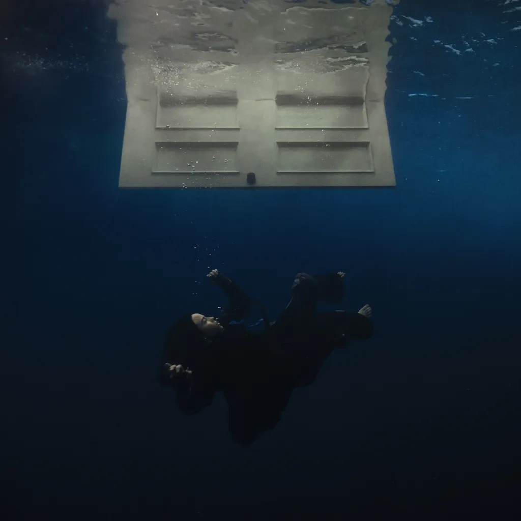 Photo: An album cover of a girl floating in the water under an open door