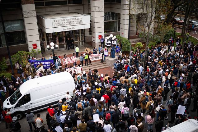 Photo: A crowd of many people gathered in front of an academic building