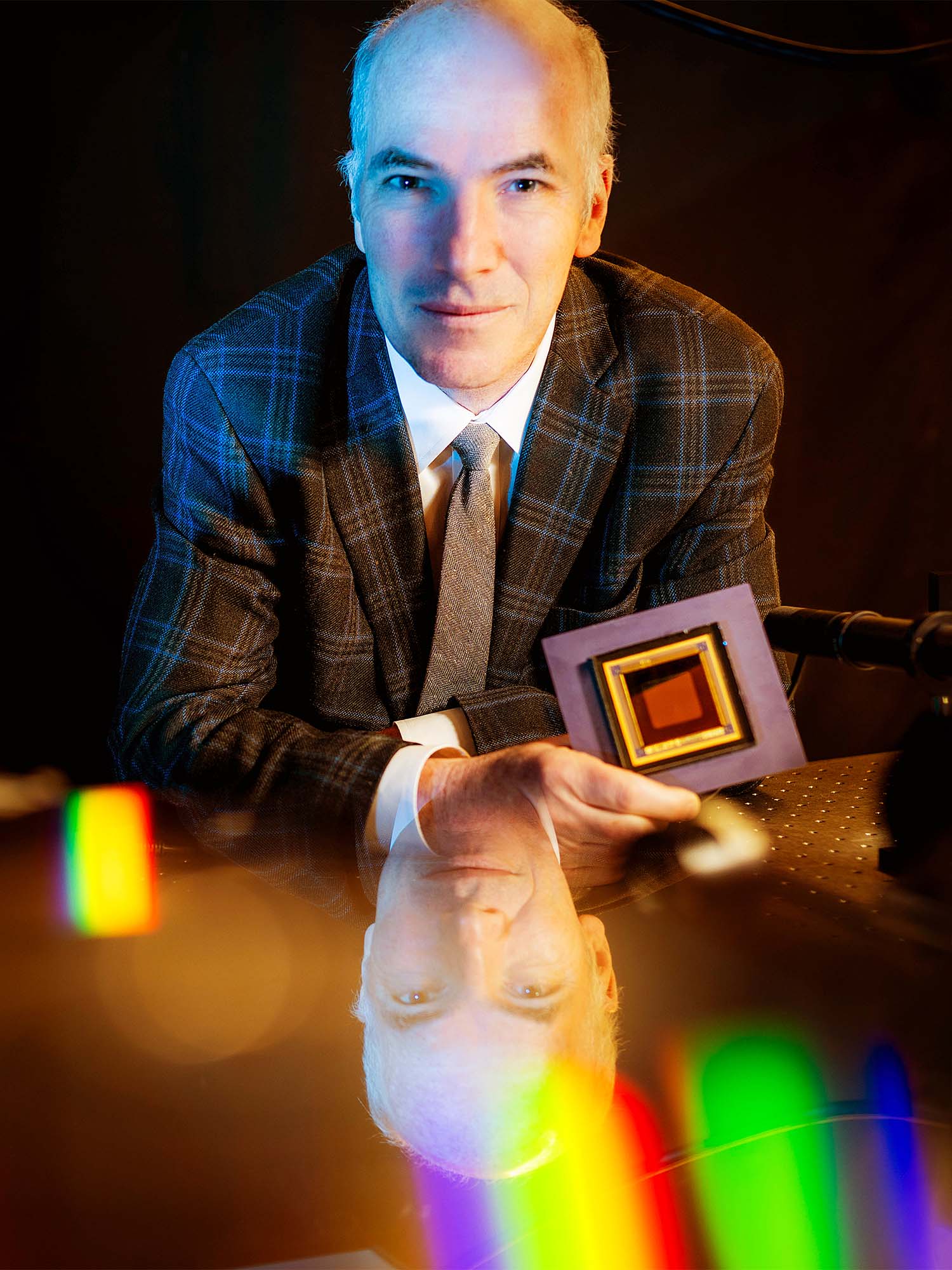 Photo: A picture of a man in a dark plaid suit looking at the camera