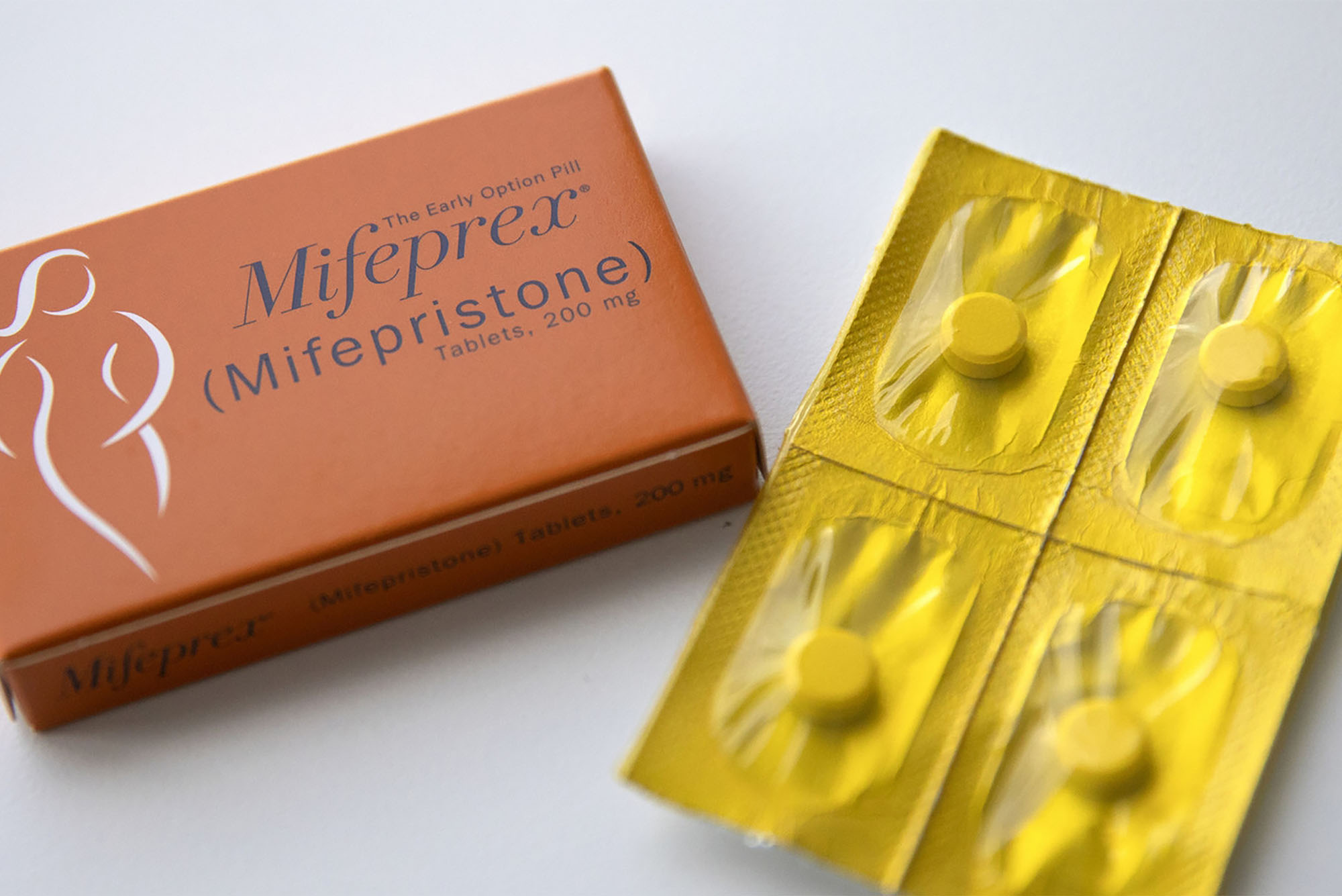 Photo: A box of Mifepristone abortion medication, with orange packaging and 4 tablets in sealed foil pouches