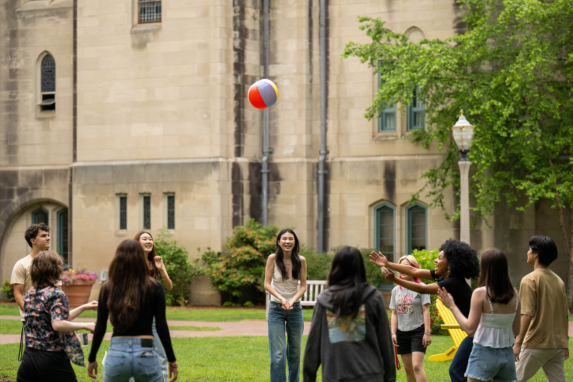 Photo: A group of students throw around an inflatable beach ball outside.