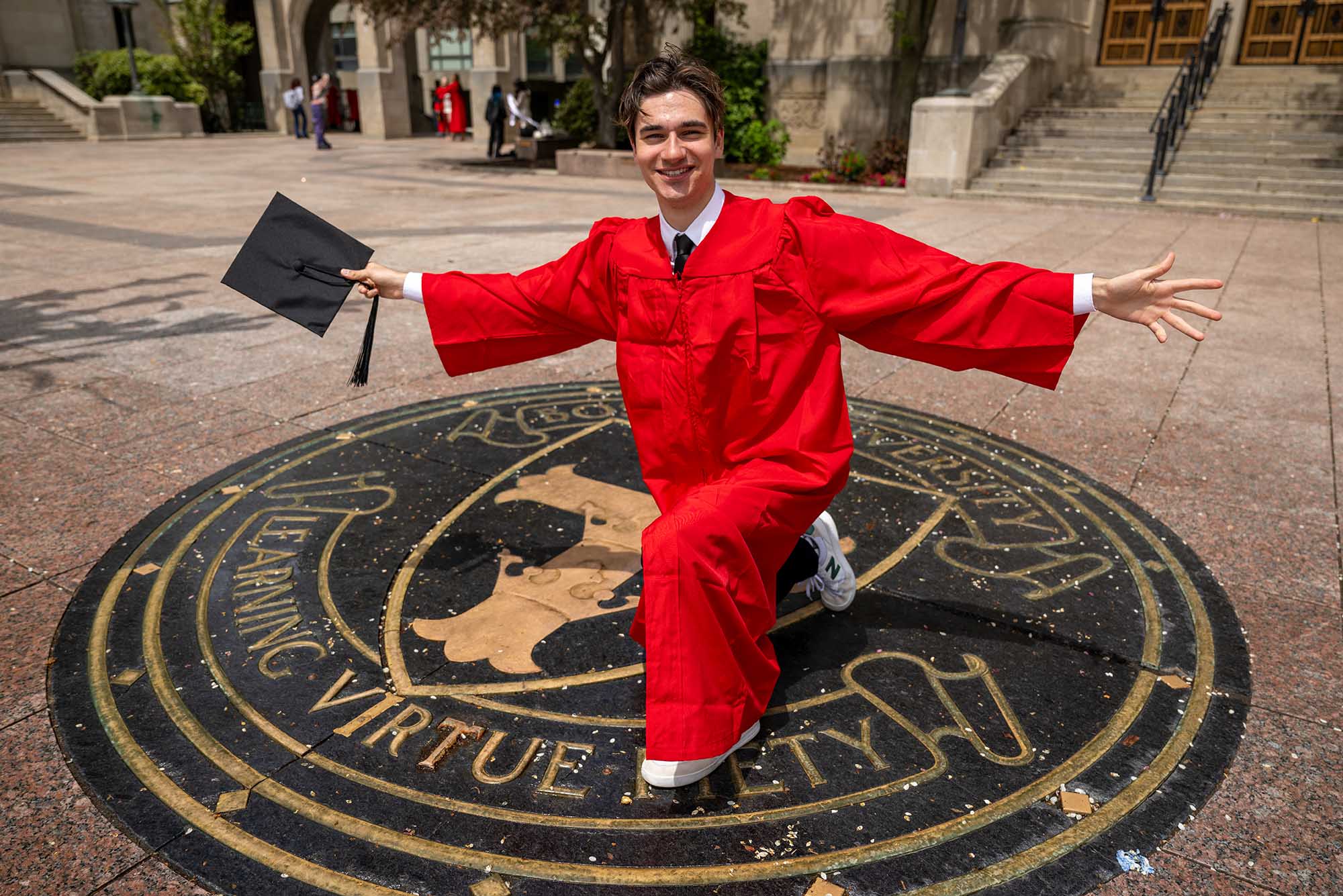 Photo: Will Loggia, a white man in his graduation cap and gown, for his vlog.