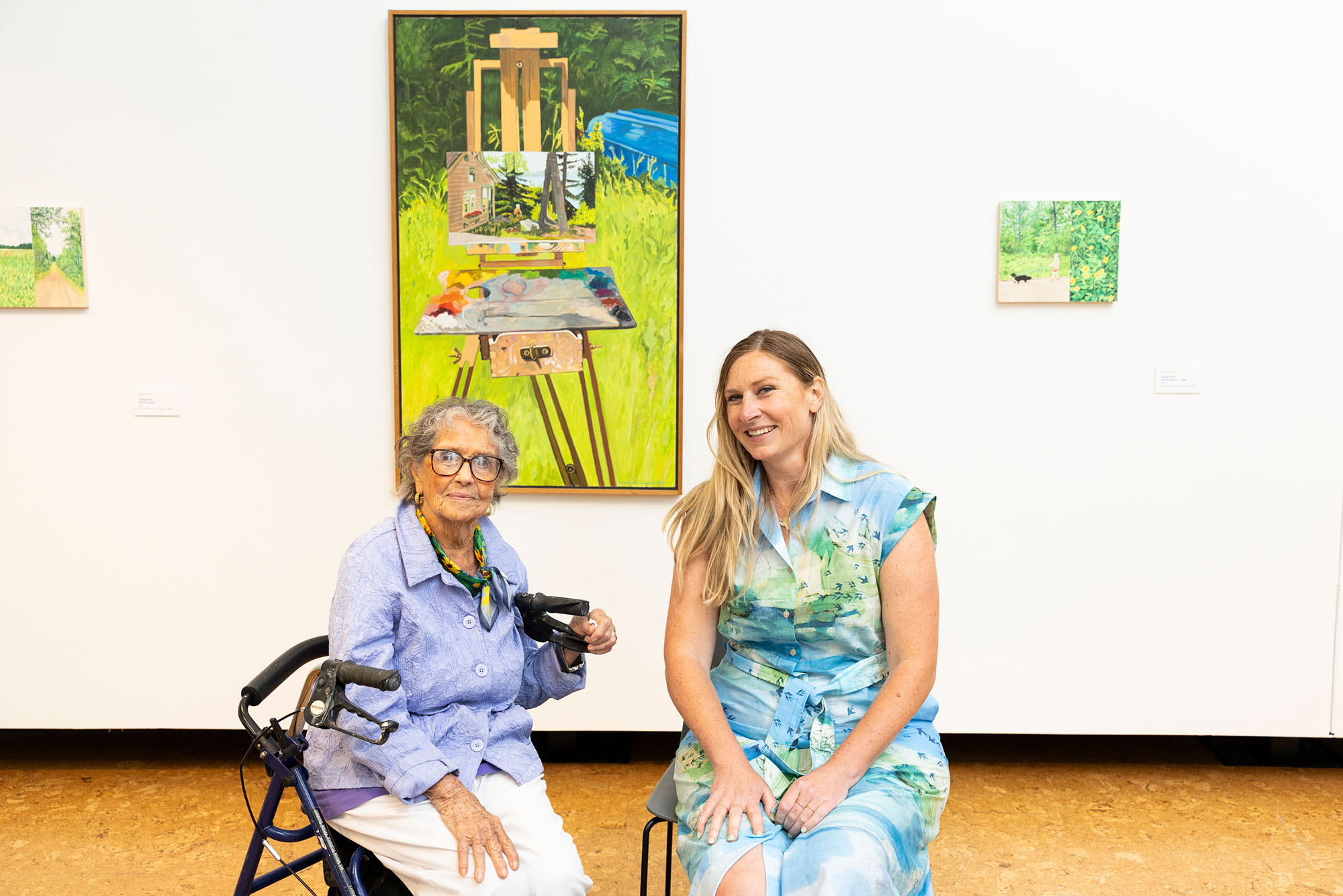 Photo: A picture of two women sitting in chairs in front of a painting