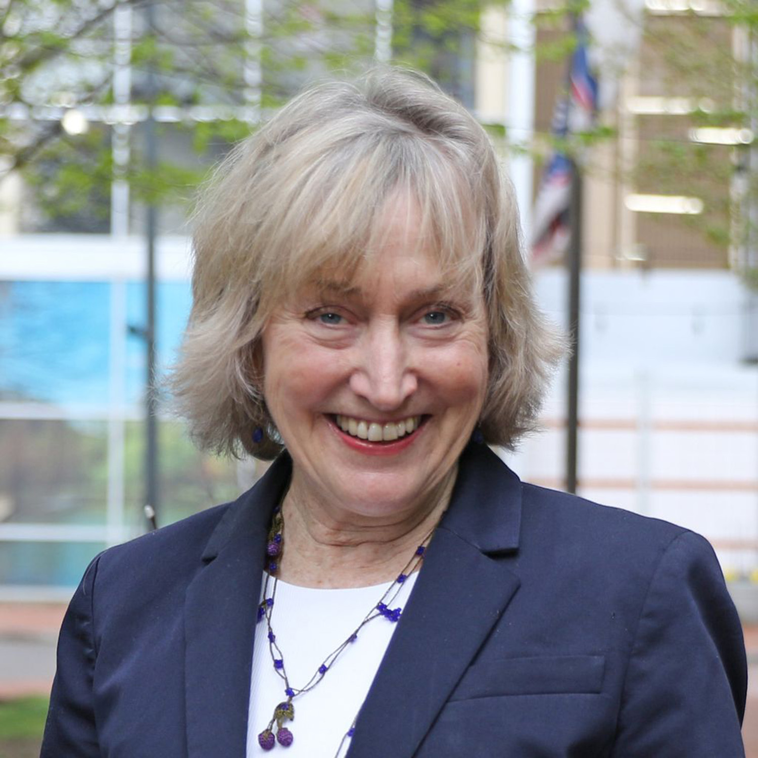Photo: A headshot of a woman with short, blonde hair wearing a suit and smiling for the camera