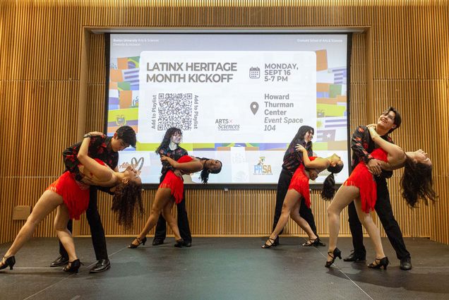 Photo: A picture of four pairs of dancers each embracing in a dipped pose in front of a projector screen that says "Latinx Heritage Month Kickoff"