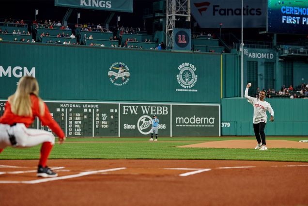 Photo: Melissa Gilliam, a black woman with short dark hair wearing a Red Sox jersey throws the ceremonial first pitch at a recent Red Sox game night honoring Boston University