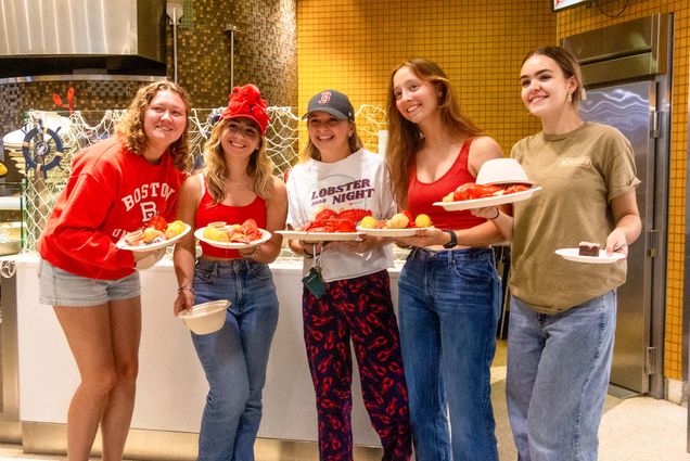 Photo: A group of college students holding plates with lobsters on them