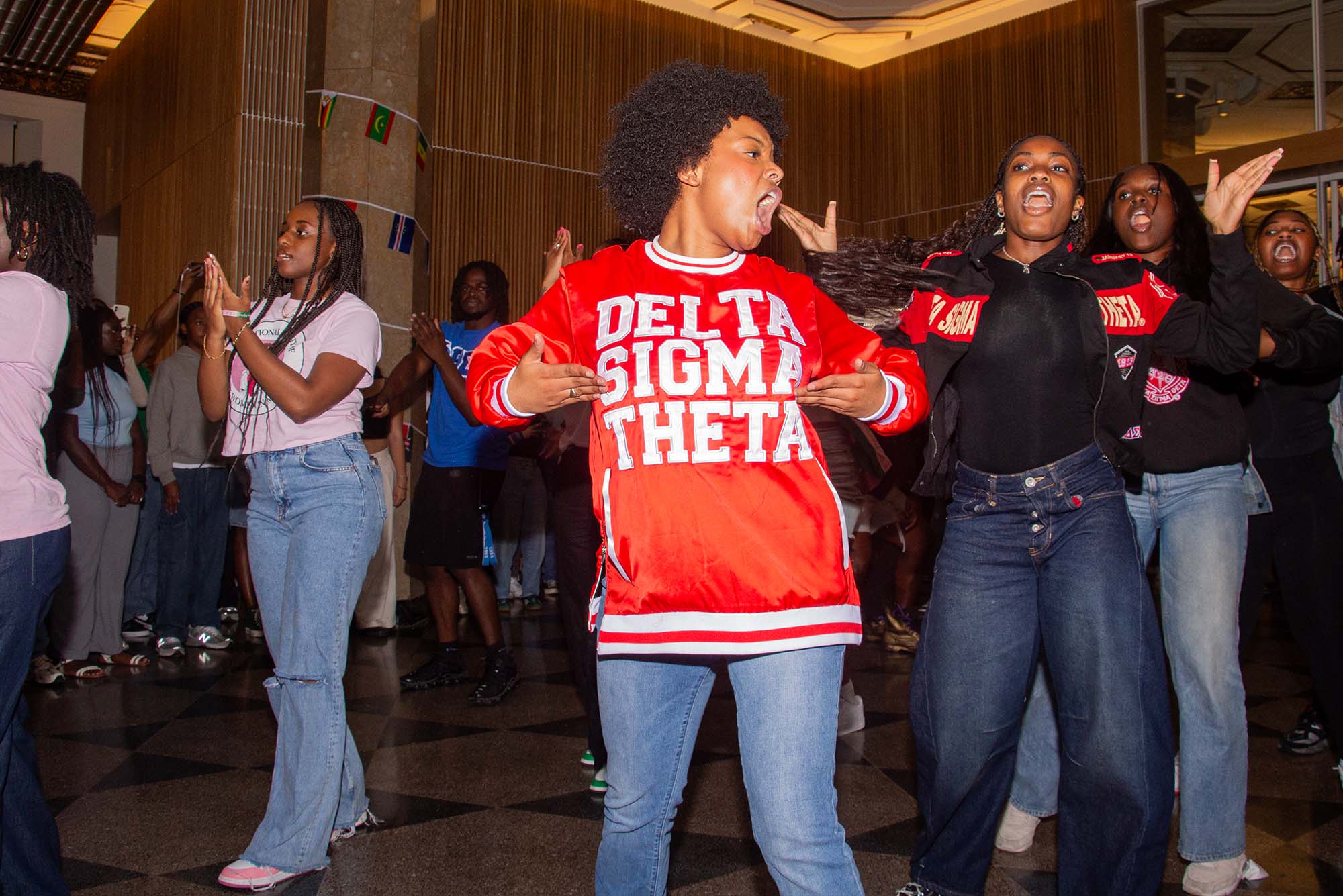 Photo: A young woman proudly displays her jersey shirt which reads: DELTA SIGMA THETA