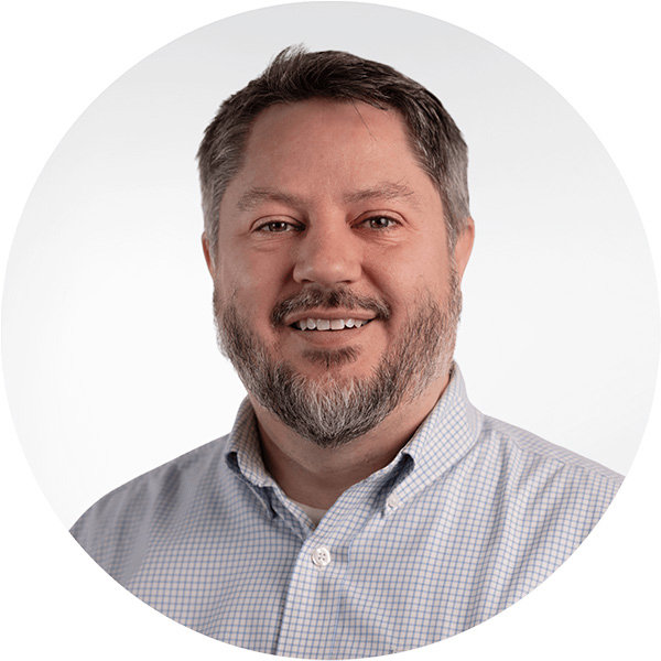 Photo: A white man wearing a collared shirt poses for a formal headshot