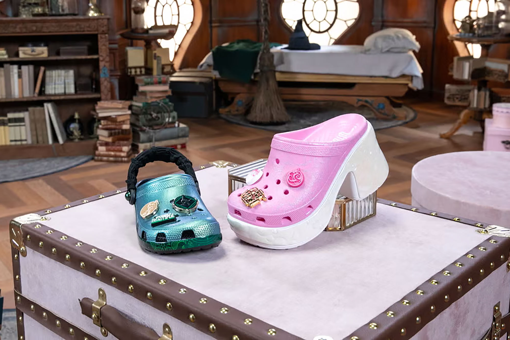 Photo: Two crocs, one green and one a pink platform, on promotional material for Wicked.