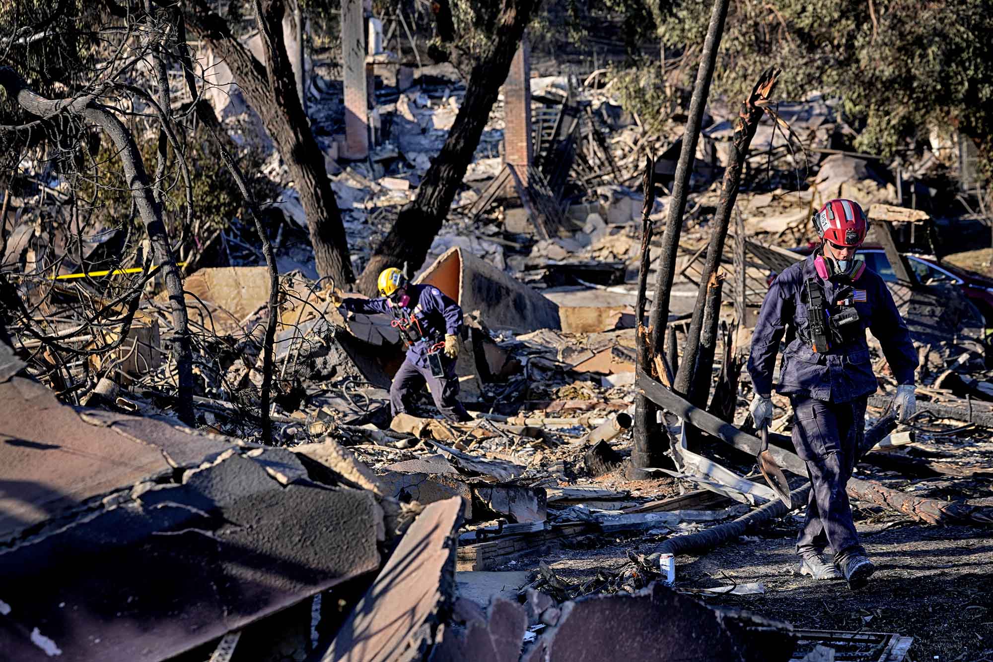 Photo: Task Force 7, a search and rescue team from Sacramento, Calif., search for remains in the rubble of a destroyed home in the Pacific Palisades neighborhood of Los Angeles