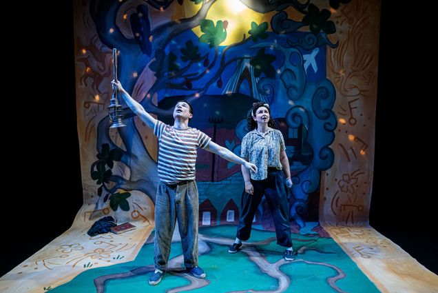 Photo: Two actors on stage looking up toward the sky. The et looks like tree branches sprawling onto the floor and into the background behind them