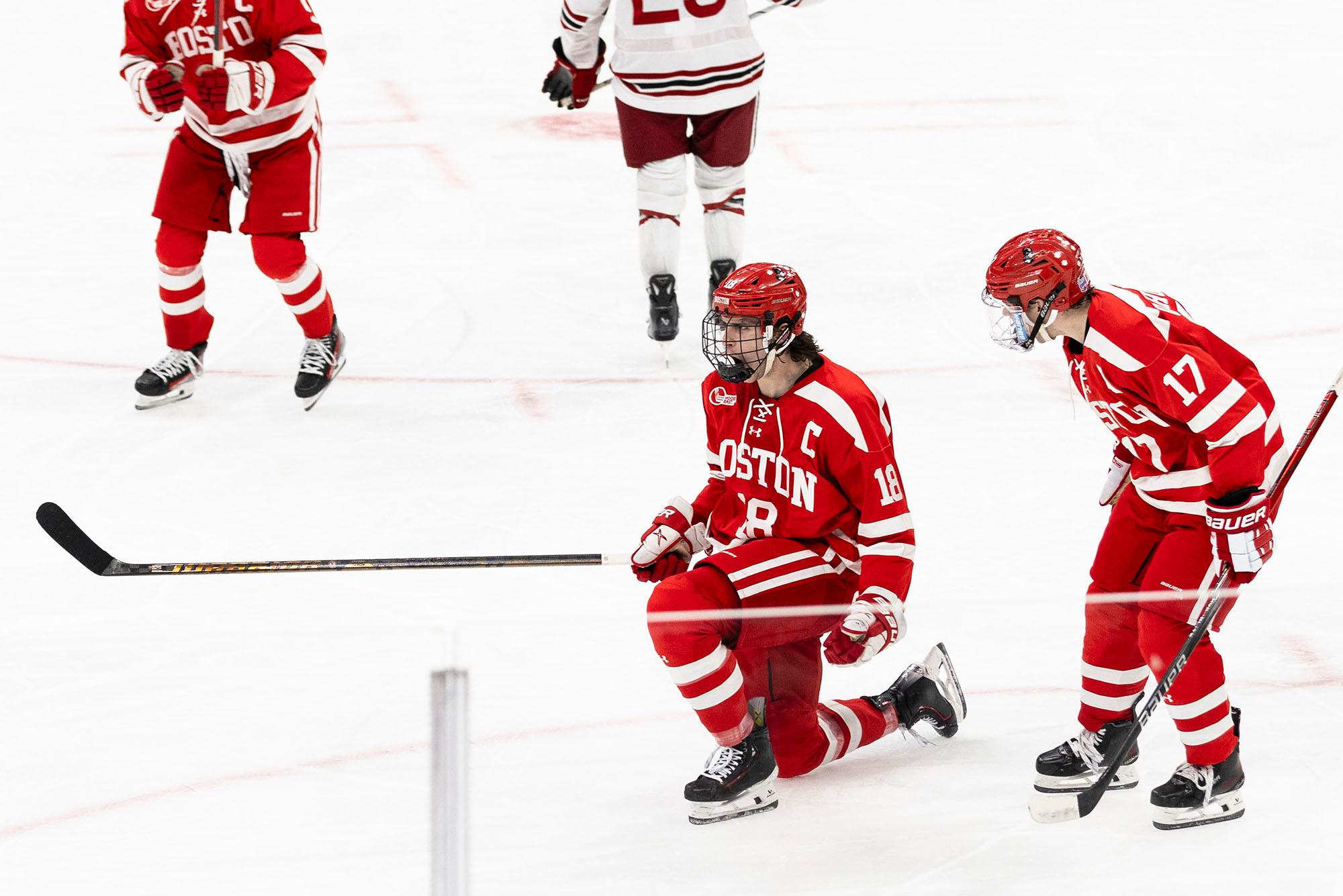 Photo: A hockey player on one knee on the ice after scoring a goal