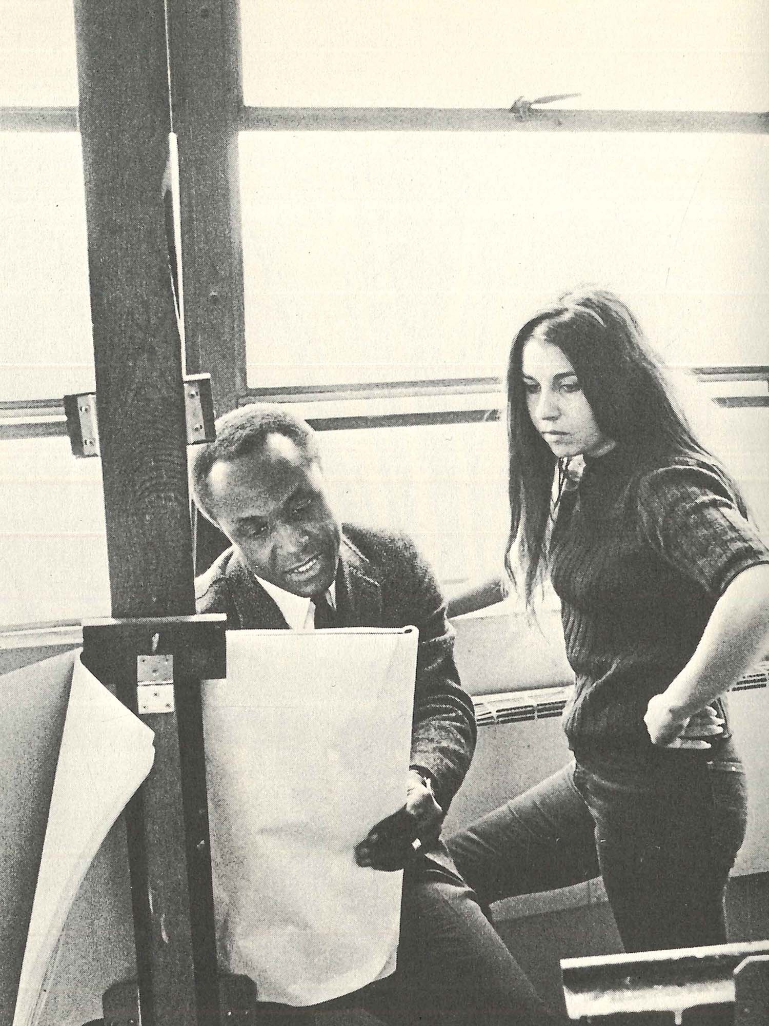 Photo: A man and a young woman look at piece of art