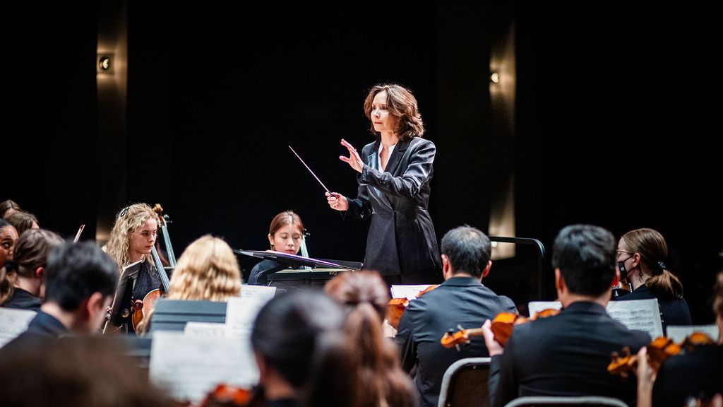Photo: Sarah Ioannides, BU's new director of orchestral activities, conducting an orchestra on stage