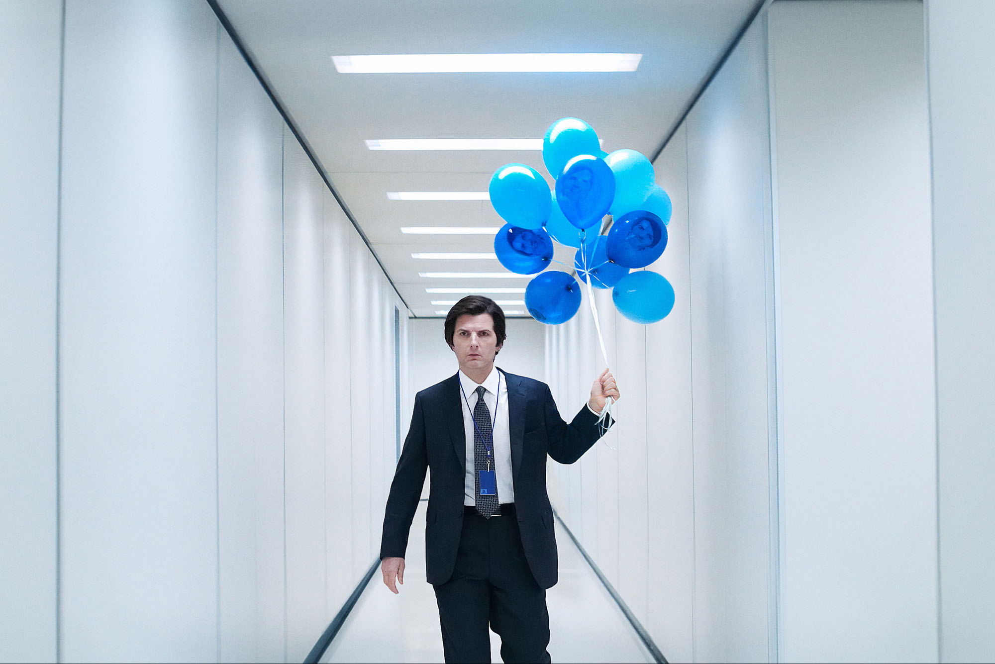 Photo: A still from the show "Severance" with Adam Scott carrying a bunch of blue balloons