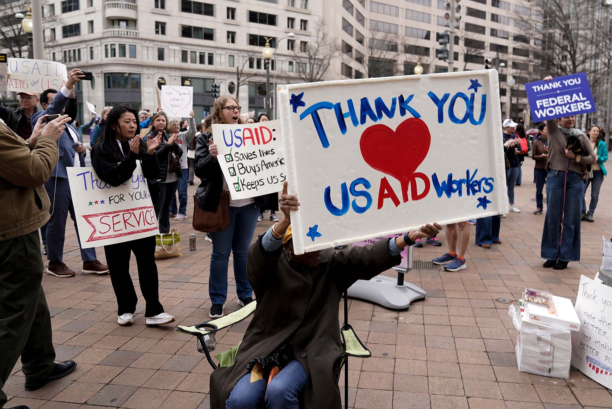 Photo: Protestors holding signs outside of USAID shuttering, one says "Thank you USAID Workers"