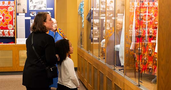 Photo: A Mother and her daughter view African Textiles in a display case.