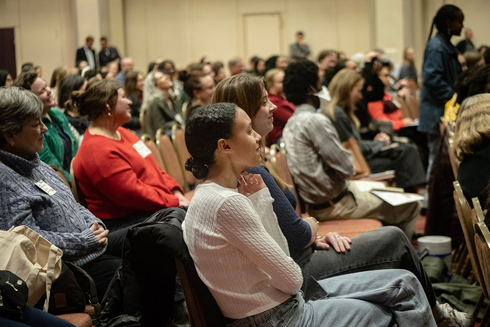 Photo: A crowd of people sitting in chairs and looking up at a stage