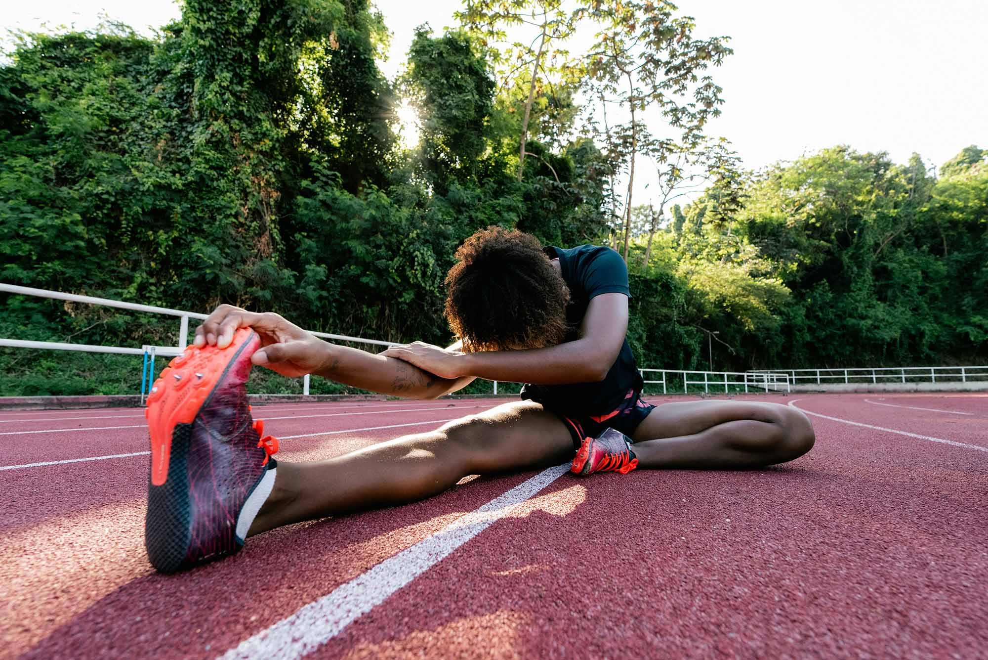 Photo: A runner stretching on a track.