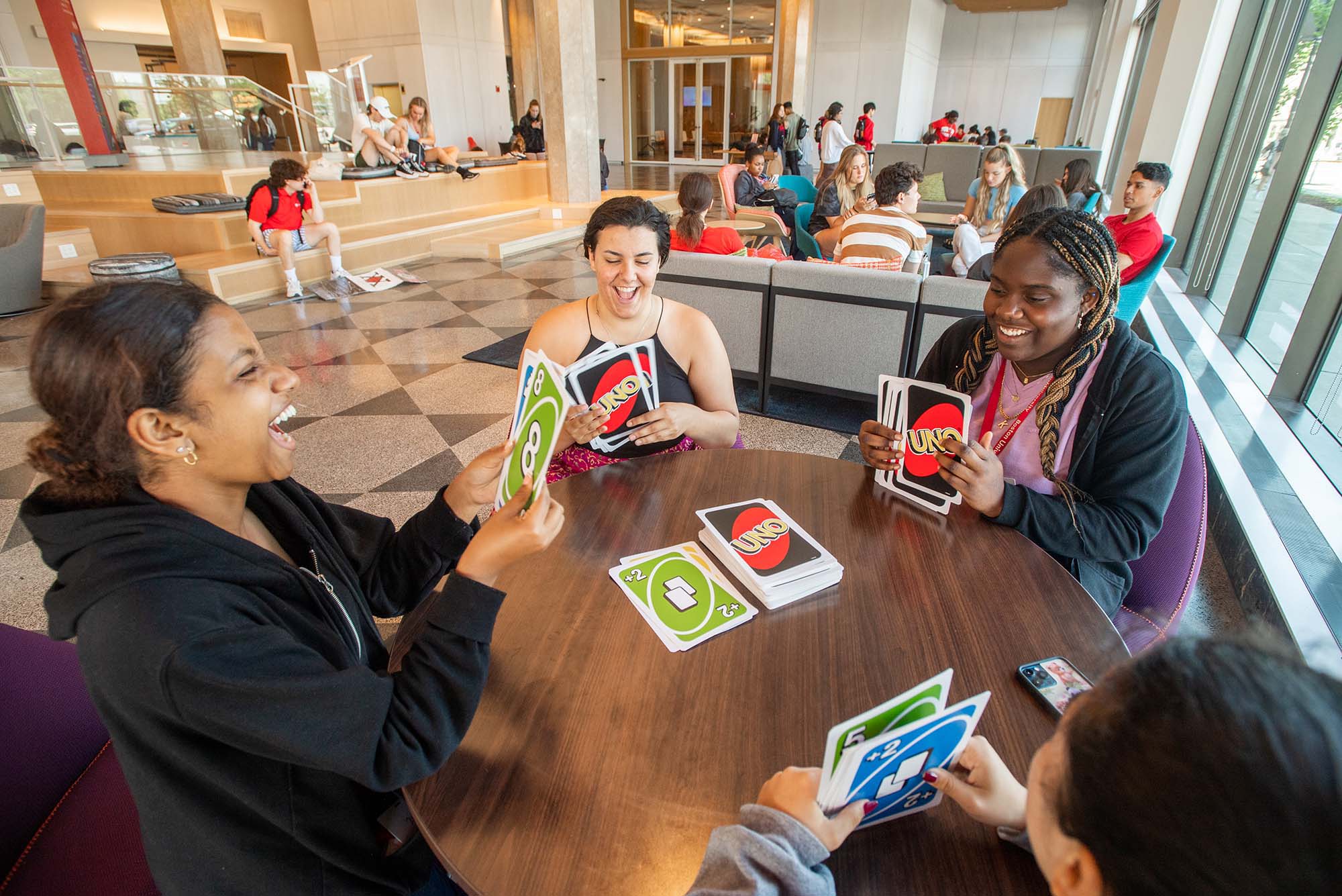 Photo: A group of people at a round table playing jumbo uno.