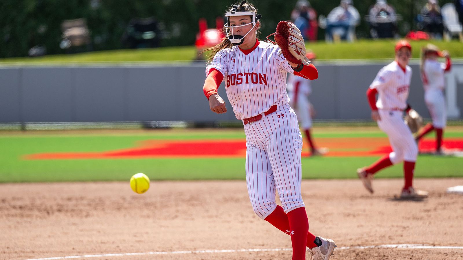 Photo: A female BU softball player pitching a ball during a game